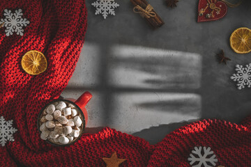 mug with drink marshmallow, red blanket on a gray background, light from window, shadow. winter, new year, christmas. top view