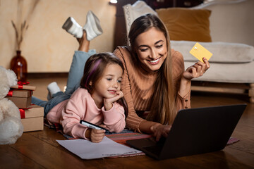 Cute girl writing letter to Santa mom using pc