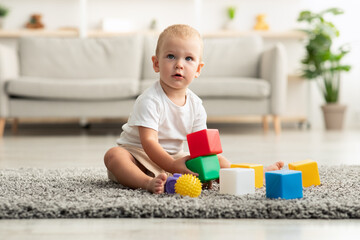 Portrait Of Cute Toddler Baby Playing With Stacking Building Blocks At Home