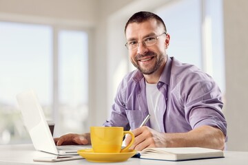 Fototapeta na wymiar Freelancer man working at home with a laptop computer