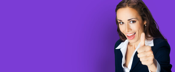 Obraz premium Businesswoman in confident black suit, showing thumbs up hand gesture, copy space for text, isolated over violet purple color background. Business concept photo.