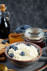 Delicious cottage cheese with blueberry, honey, strawberry jam and toast. Healthy breakfast