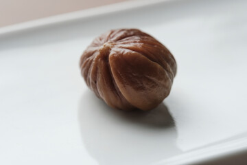 Close up photo of a roasted chesnut on a with elongated dish