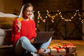 Xmas Shopping. Smiling lady using laptop showing credit card
