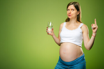 A pregnant woman with a glass of water, should a pregnant woman drink a lot of water or not....