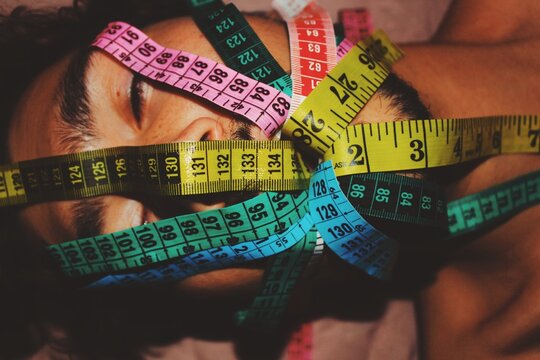 abstract art portrait of young man with measuring tapes through mouth on body dysmorphia, self image, height