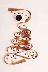 Christmas tree made of satin ribbon decorated with coffee beans and pearl balls. Cup of black coffee