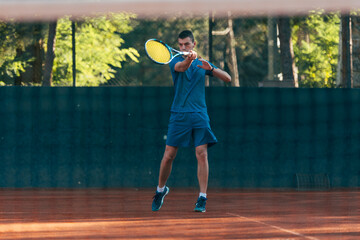 Strong male tennis player observed through the tennis net