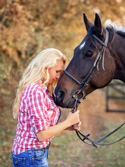 Obraz premium beautiful caucasian girl with a horse in the forest at sunset