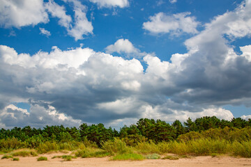 Panorama of the warm Gulf of Riga of the Baltic Sea against the background of cumulus clouds. The coast of the Gulf of Riga in Latvia is popular with tourists.