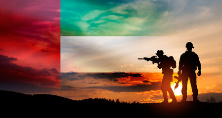 Fototapeta premium Silhouette of soldiers against the flag of UAE. Concept of national holidays.