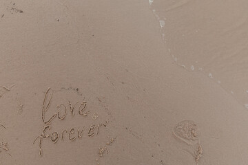 lettering love forever on the beach sand