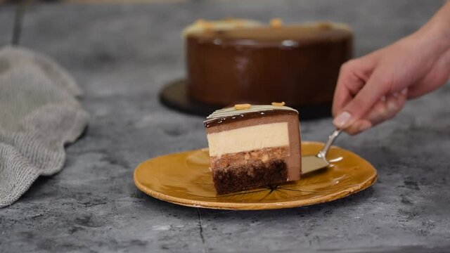 Piece of chocolate caramel peanut mousse cake, snickers on a plate.