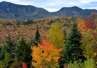 Autumn in White Mountain National Forest of New Hampshire. Scenic view from Kancamagus Highway of Mount Osceola and Scar Ridge with colorful hillside of vibrant fall foliage.