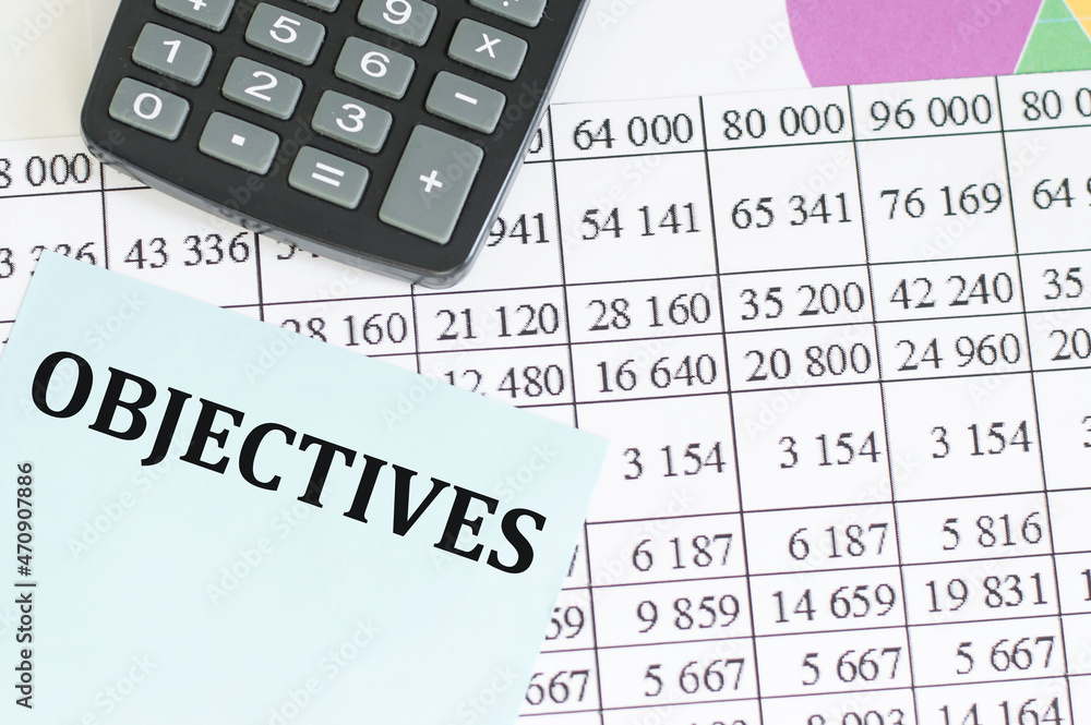 Poster text objectives on a card against the background of accounting reports next to the calculator