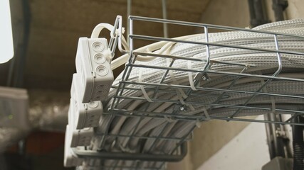 Electrical Box Power Cables and Telecommunication Wiring Tied in Basket Hanging Under Ceiling in Residential Building Basement	