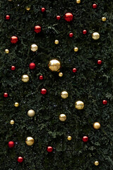 Texture of Christmas balls hanging on a huge background of green leaves representing a Christmas tree, Madrid, Spain