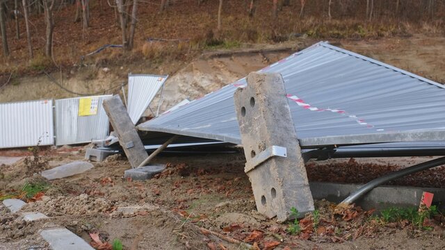 Messy Demolished Construction Site with Overturned Metal Sheet Fence Devasted and Damaged by Strong Gale Wind Tornado Hurricane	