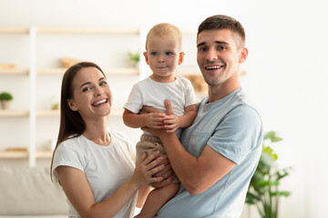 Family Care. Portrait Of Happy Young Parents And Their Cute Infant Child