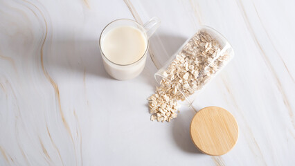 Oat flakes on a glass bowl and jug of milk