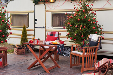 Christmas tree background. Van mobile trailer, mobile home, terrace. New Year celebration. Winter holidays. Christmas morning. Camper van in camp ground, caravan van.