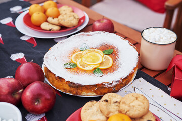 Christmas pie, cocoa with marshmallows and table. Christmas tree background. Van mobile trailer, mobile home, terrace. New Year celebration. Winter holidays. Christmas morning.