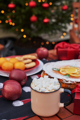 Christmas pie, cocoa with marshmallows and table. Christmas tree background. Van mobile trailer, mobile home, terrace. New Year celebration. Winter holidays. Christmas morning.