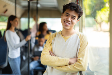 Smiling asian guy taking bus, looking at camera © Prostock-studio