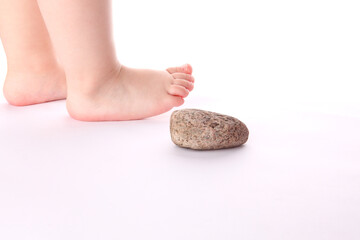 Kamień - stopa dziecka - przeszkoda - symbol równowagi i niewinności  - obrazy, fototapety, plakaty