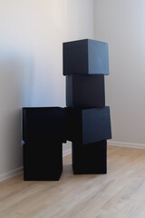 Black boxes in the shape of a cube on the background of an old wall