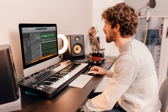 Professional male music producer, composer working in recording home studio. Music production concept.
