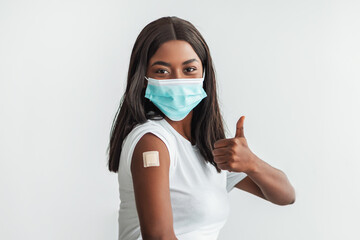 Lady In Mask Showing Shoulder With Patch And Thumbs Up