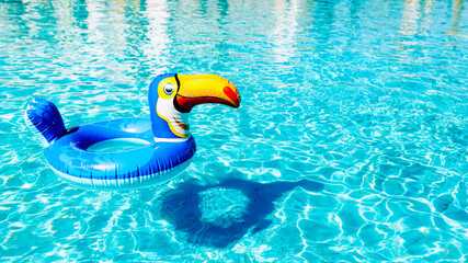Children's inflatable lifebuoy swim ring floats on the water in the pool