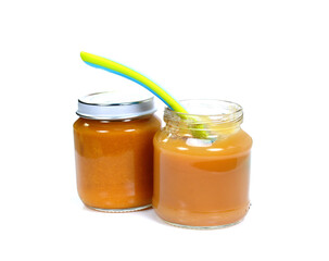 Baby fruit puree jar and spoon isolated on white.