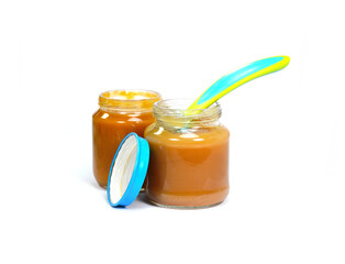 Baby fruit puree jar and spoon isolated on white.