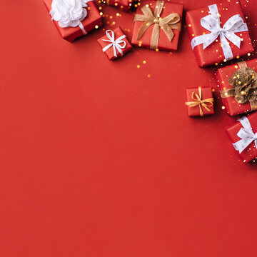 Gift boxes with white and brown bows on a red backdrop.