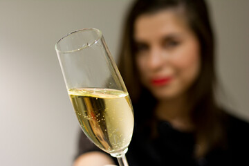 Close up cropped photo of female hold in hand glass of champagne with blurred background. Concept: celebrate christmas and new year Valentine's Day Women's Day birthday holiday party 