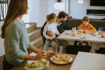 Young mother preparing breakfast for her family in the kitchen