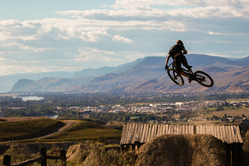 Downhill Mountain Biker at the Kamloops Bike Ranch riding the third gap jump on Fist Full of...