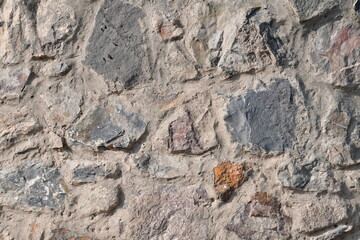 Background, texture of natural stone. An old wall on cement made of large stones.