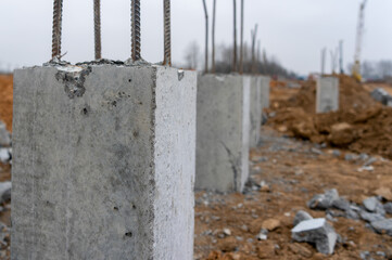 Photo of construction metal rods in concrete pillars against the background of a construction site...