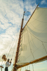 raising the sail on a historic  gaff-rigged 