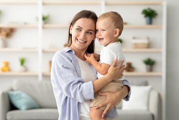 Happy Beautiful Young Mother Cuddling Her Adorable Infant Baby Son At Home