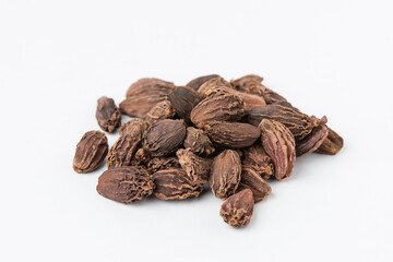 Macro photo of pile black whole dried cardamom seeds on a white background with copy space