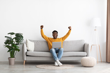 Happy black guy celebrating success, gambling online