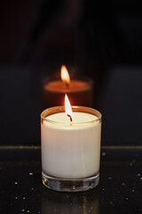 Obraz na płótnie Canvas a burning candle with a glass glass glass glass against a dark background
