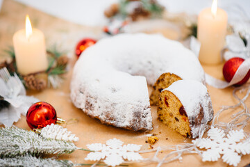 Traditional round Christmas stollen made of dried fruits and nuts sprinkled with powdered sugar on...