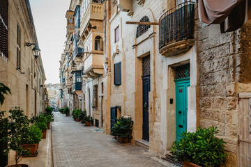 Traditional colorful Maltese doors in Valletta. Front doors to houses from Malta. Blue green doors and wooden balcony. Maltese vintage apartment buildings.Popular travel destination. Entrance to house