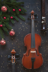 Two Old violins and flute with fir-tree branches with Christmas decor. Christmas and New Year's concept. Top view, close-up