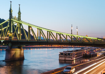 A panoramic view of the Liberty Bridge and buildings in Budapest. Colorful evening view in Budapest, Hungary, Europe.